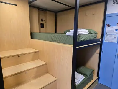 a room with three bunk beds on a boat at Los Tres Abetos in Arzúa