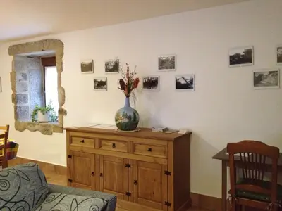 a room with two beds and a chandelier at Alojamiento Pazos in Cea