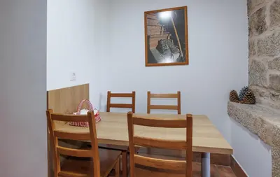 a living room with a wooden table and chairs at Alojamiento Pazos in Cea