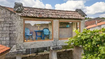a stone building with a picnic table in front of it at Alojamiento Pazos in Cea
