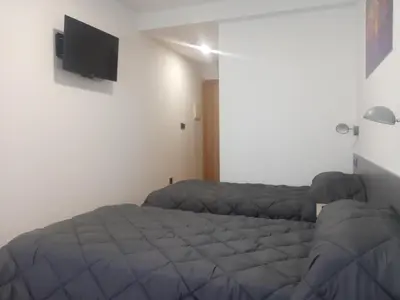 a bedroom with a bed and a flat screen tv at Hostal Outarelo in Ourense