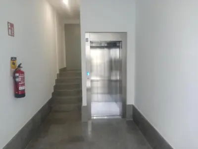 an elevator in a building with stairs and a fire extinguisher at Hostal Outarelo in Ourense
