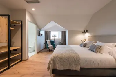 a bedroom with a large bed and a bathroom at Hotel Rías Altas in Barreiros