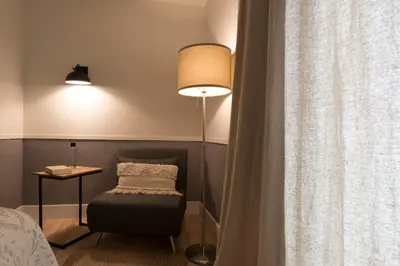 a room with a lamp and a chair next to a window at Hotel Rías Altas in Barreiros