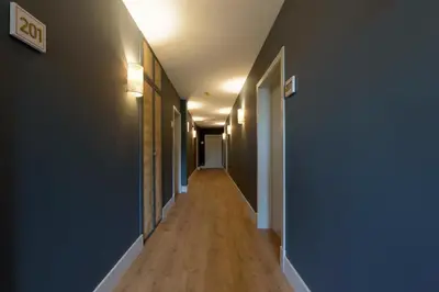 a long hallway with blue walls and a wooden floor at Hotel Rías Altas in Barreiros