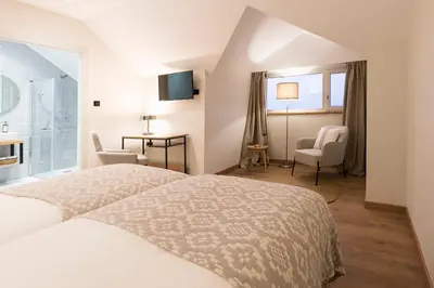 a hotel room with a bed and a bathroom at Hotel Rías Altas in Barreiros