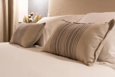 a row of pillows on a white bed at Hotel Rías Altas in Barreiros