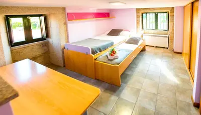 a small room with two beds and a table at CASA BELAI in Cuntis