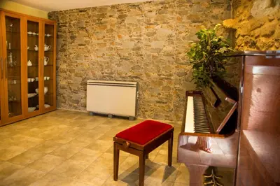 a music room with a piano and a chair at CASA BELAI in Cuntis