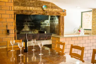 a table with wine glasses on it with a fireplace at CASA BELAI in Cuntis