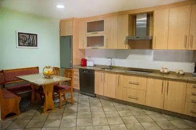 a kitchen with wooden cabinets and a table and a table and chairs at CASA BELAI in Cuntis