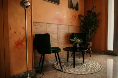 two green chairs and a table in a room at PENSIÓN BERENGUELA in Melide
