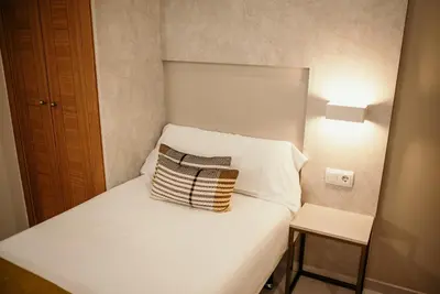 a small bedroom with a bed with a pillow on it at PENSIÓN BERENGUELA in Melide