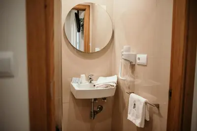 a bathroom with a sink and a mirror at PENSIÓN BERENGUELA in Melide