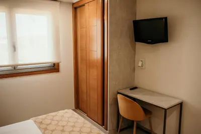 a small room with a desk and a television at PENSIÓN BERENGUELA in Melide