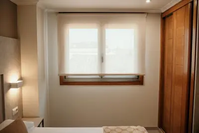 a window in a room with a bed and a window seat at PENSIÓN BERENGUELA in Melide