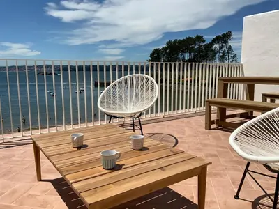 a patio with a table and chairs and the water at Oktheway Perbes Beach in Boebre