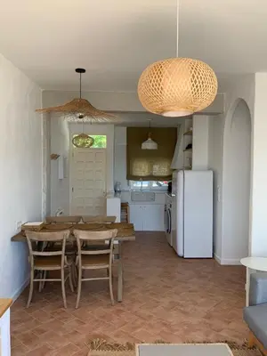 a kitchen and dining room with a table and a refrigerator at Oktheway Perbes Beach in Boebre