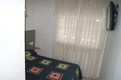 a bedroom with a bed and a window with curtains at Gran Vía in Lugo