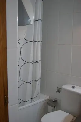 a bathroom with a toilet and a shower curtain at Gran Vía in Lugo