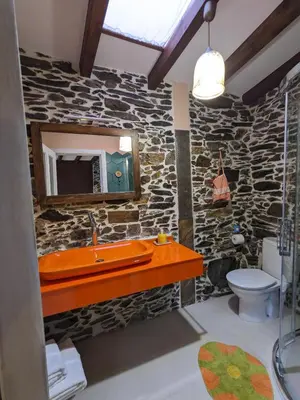 a stone bathroom with a sink and a mirror at Casa do Estevo in Francos