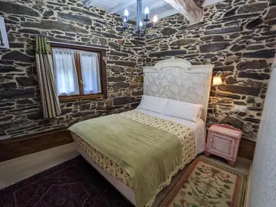 a bedroom with a bed in a stone wall at Casa do Estevo in Francos