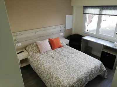a bedroom with a bed with two pillows on it at Pensión La Intermodal in Santiago de Compostela