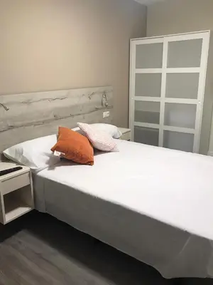 a large white bed with two pillows on it at Pensión La Intermodal in Santiago de Compostela