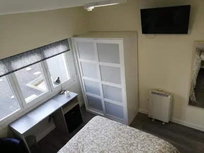 a bedroom with a bed and a desk and a window at Pensión La Intermodal in Santiago de Compostela
