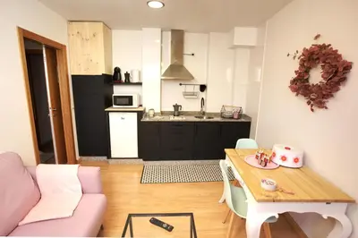 a living room with a table and a kitchen at VM Apartamentos Turísticos in Santiago de Compostela