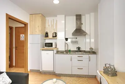 a kitchen with white cabinets and a sink at VM Apartamentos Turísticos in Santiago de Compostela