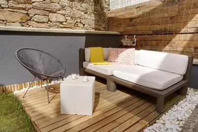 a white couch sitting on a wooden deck at VM Apartamentos Turísticos in Santiago de Compostela