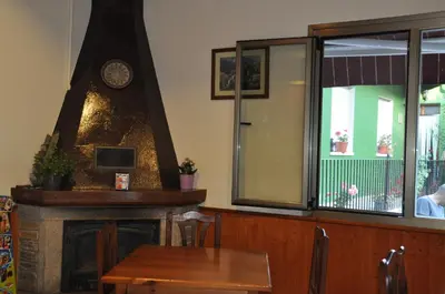 a fireplace in a restaurant with a table and a clock at Casa Polín in Las Herrerías