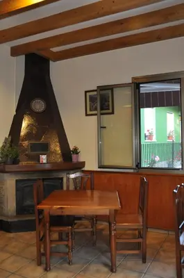 a dining room with a fireplace and a table at Casa Polín in Las Herrerías