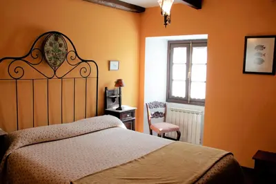 a bedroom with a bed and a window and a chair at Casa San Ginés in Cruces