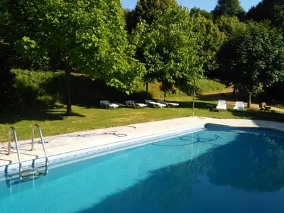 a large blue swimming pool with chairs and trees at Casa San Ginés in Cruces