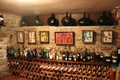 a bar with bottles of wine and clocks on the wall at Casa San Ginés in Cruces