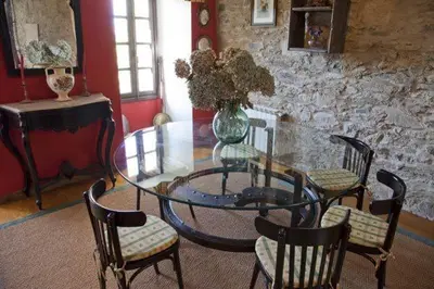 a glass table with chairs and a vase with flowers on it at Casa San Ginés in Cruces