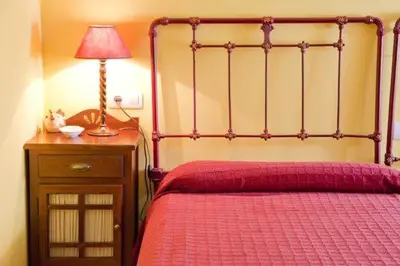 a bedroom with a red bed with a lamp on a night stand at Casa San Ginés in Cruces