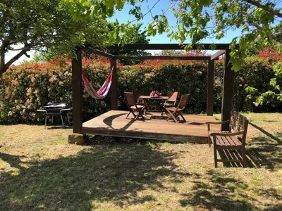 a wooden deck with a table and chairs in a garden at Ribeira sacra ourense in Ourense