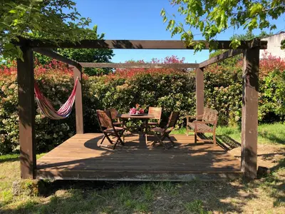 a wooden deck with a hammock and a table and chairs at Ribeira sacra ourense in Ourense