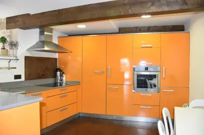 an orange kitchen with orange cabinets and a microwave at Ribeira sacra ourense in Ourense
