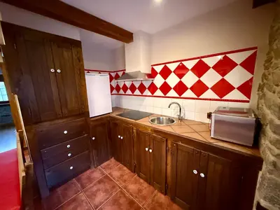 a kitchen with wooden cabinets and a sink at Casa Rural Bango in Caboalles de Abajo