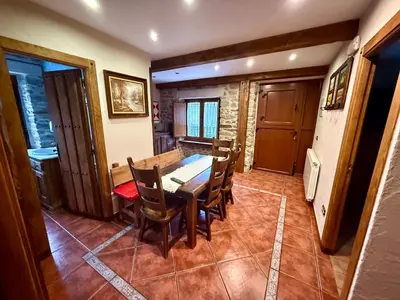 a dining room with a wooden table and chairs at Casa Rural Bango in Caboalles de Abajo