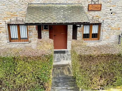 an entrance to a stone building with a red door at Casa Rural Bango in Caboalles de Abajo