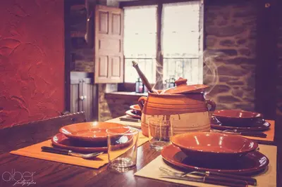 a table with plates and bowls on top of it at Casa Rural Bango in Caboalles de Abajo