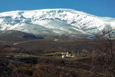 a snow covered mountain with a town in the foreground at CASA CAMARGA in Santiago Millas