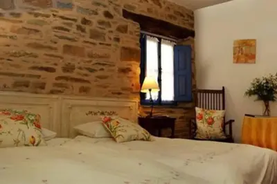 a bedroom with a bed and a brick wall at CASA CAMARGA in Santiago Millas
