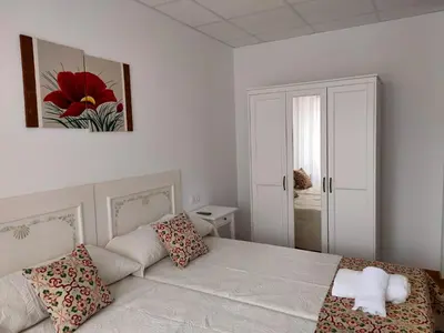 a white bedroom with a bed and a couch at Lar do Peregrino in Palas de Rei