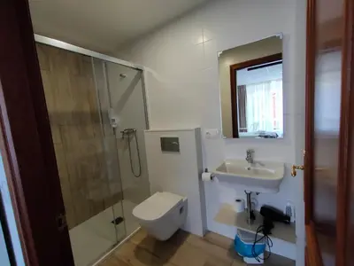 a bathroom with a toilet and a sink and a shower at Lar do Peregrino in Palas de Rei